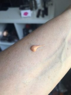 A small blob of Kiehls Glow Lotion Skin Hydrator on an arm to show the colour