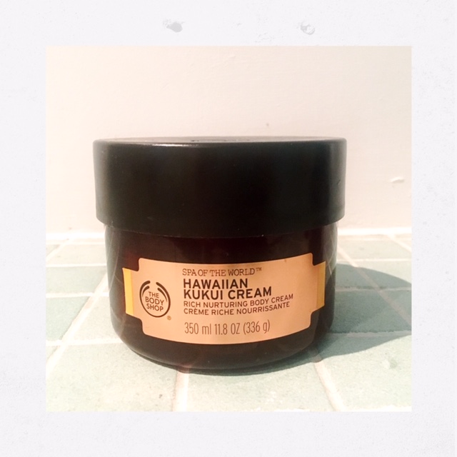 A tub of The Body Shop Hawaiian Kukui Cream body butter on turquoise tiles 